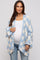 woman wearing a light blue and white checkered maternity cardigan over a white top and showing her baby bump