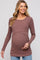 woman wearing a mauve ribbed long sleeve maternity top and holding her baby bump