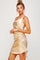woman wearing a gold satin sleeveless mini dress with side ruching and adjustable ties