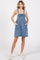 woman wearing a denim overall dress with large front pockets and a relaxed fit, paired with a light top and sneakers