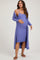 woman wearing a purple ribbed maternity dress with a long cardigan and showing her baby bump