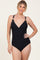 woman wearing a black ribbed one-piece swimsuit with adjustable straps and gathered details