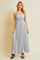 woman wearing a light grey pleated maxi dress with spaghetti straps and a sweetheart neckline