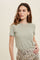 woman wearing a light green short sleeve ribbed top paired with a beige leopard print skirt