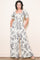 woman wearing a cream floral print jumpsuit with puff sleeves and side pockets