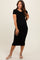 woman wearing a black ribbed maternity dress that highlights her baby bump, styled with white sandals
