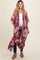woman wearing a floral maternity kimono in shades of pink and burgundy with an open front and relaxed fit, holding her baby bump