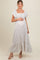 woman wearing a light floral print maternity maxi dress with short flutter sleeves and a visible baby bump