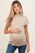 woman wearing a beige short sleeve maternity top and holding her baby bump