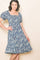 woman wearing a navy blue floral print midi dress with puff sleeves and a square neckline