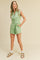 woman wearing a light green sleeveless romper with front buttons and side pockets