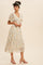 woman wearing a white floral midi dress with short flutter sleeves and pink block heel sandals