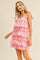 woman wearing a playful pink tiered ruffle dress with eyelet detailing, featuring thin straps and a relaxed fit
