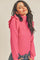woman wearing a pink ribbed turtleneck sweater with ruffle shoulder details and blue jeans