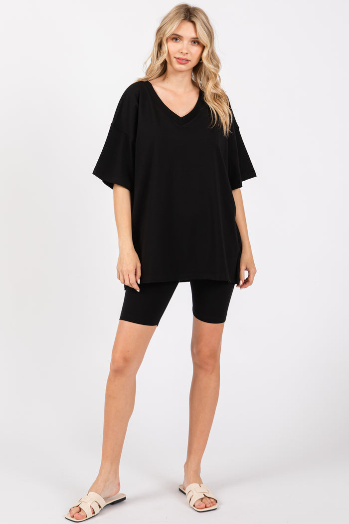 woman wearing an oversized black v-neck t-shirt with black biker shorts and sandals