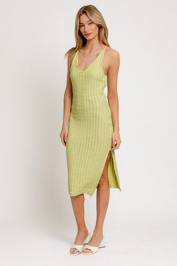 woman wearing a light green knitted midi dress with side slit and thin straps
