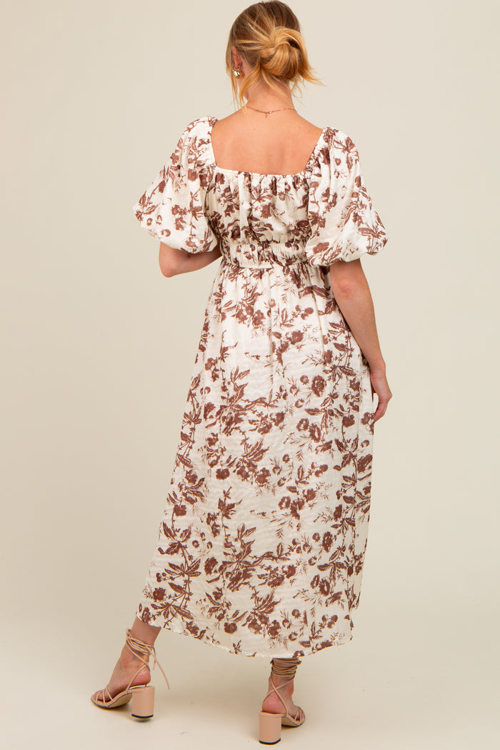 woman wearing a floral print maternity maxi dress with puff sleeves and gathered back details
