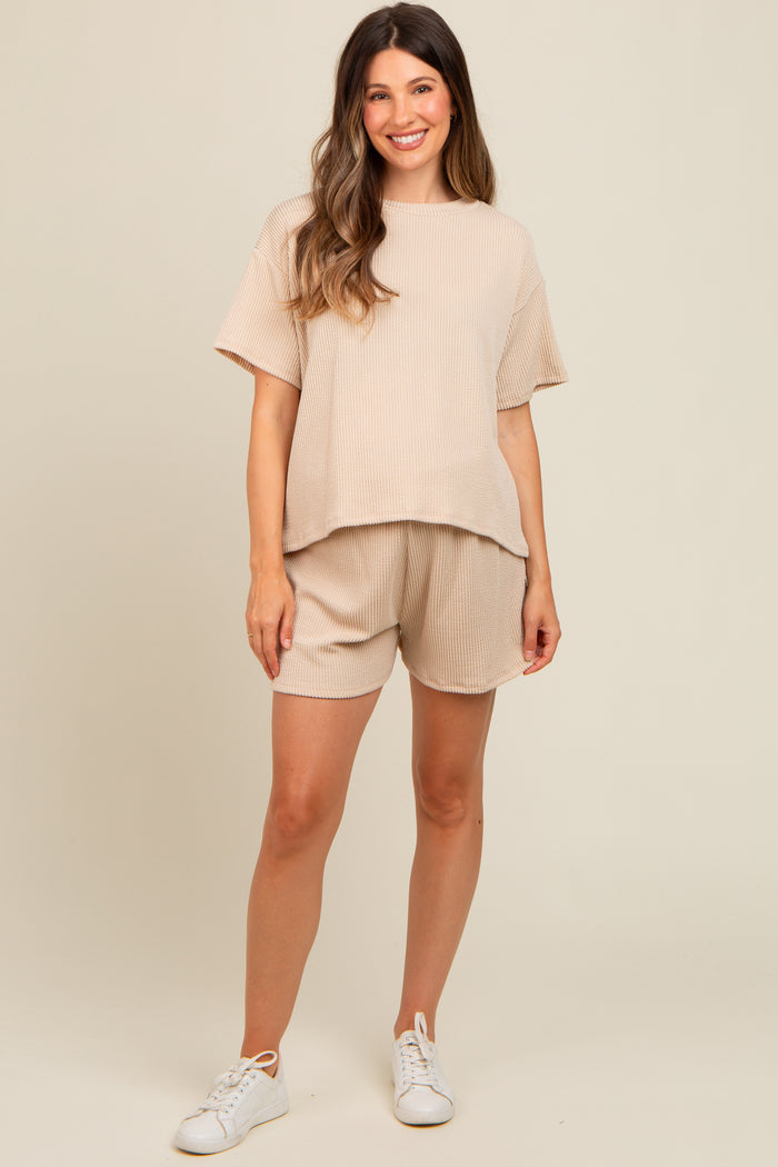 woman wearing a beige ribbed maternity top and matching shorts with a relaxed fit