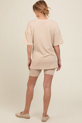 woman wearing a beige striped maternity loungewear set consisting of a loose t-shirt and shorts