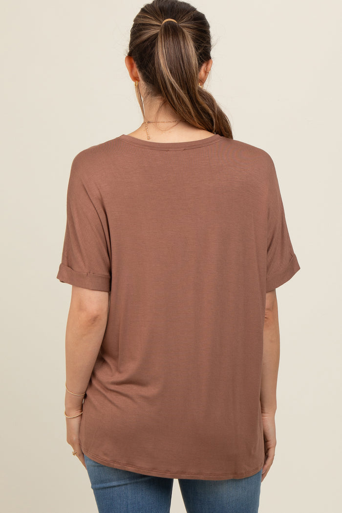 woman wearing a brown maternity top with rolled sleeves and a relaxed fit, viewed from the back