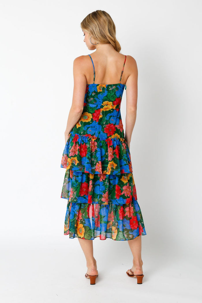 woman wearing a colorful floral tiered maxi dress with a spaghetti strap back detail