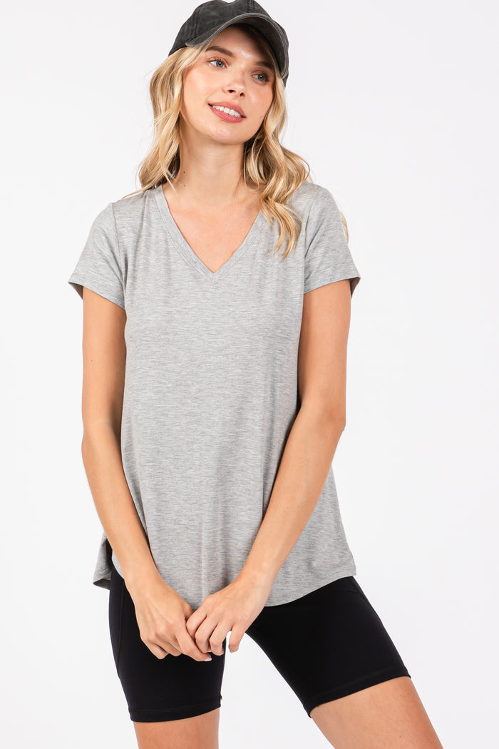 woman wearing a gray v-neck short sleeve top with a relaxed fit and black bike shorts