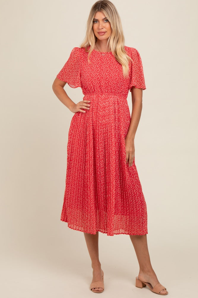 woman wearing a red floral midi dress with short sleeves and a pleated skirt