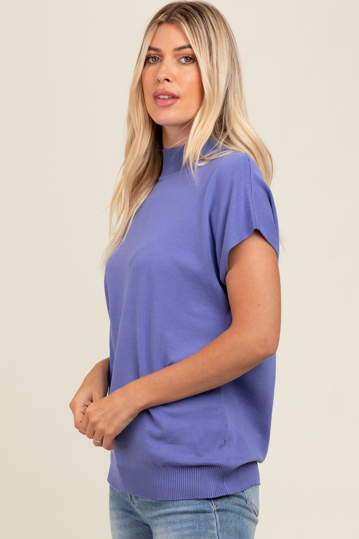 woman wearing a lavender short sleeve mock neck top paired with light blue jeans