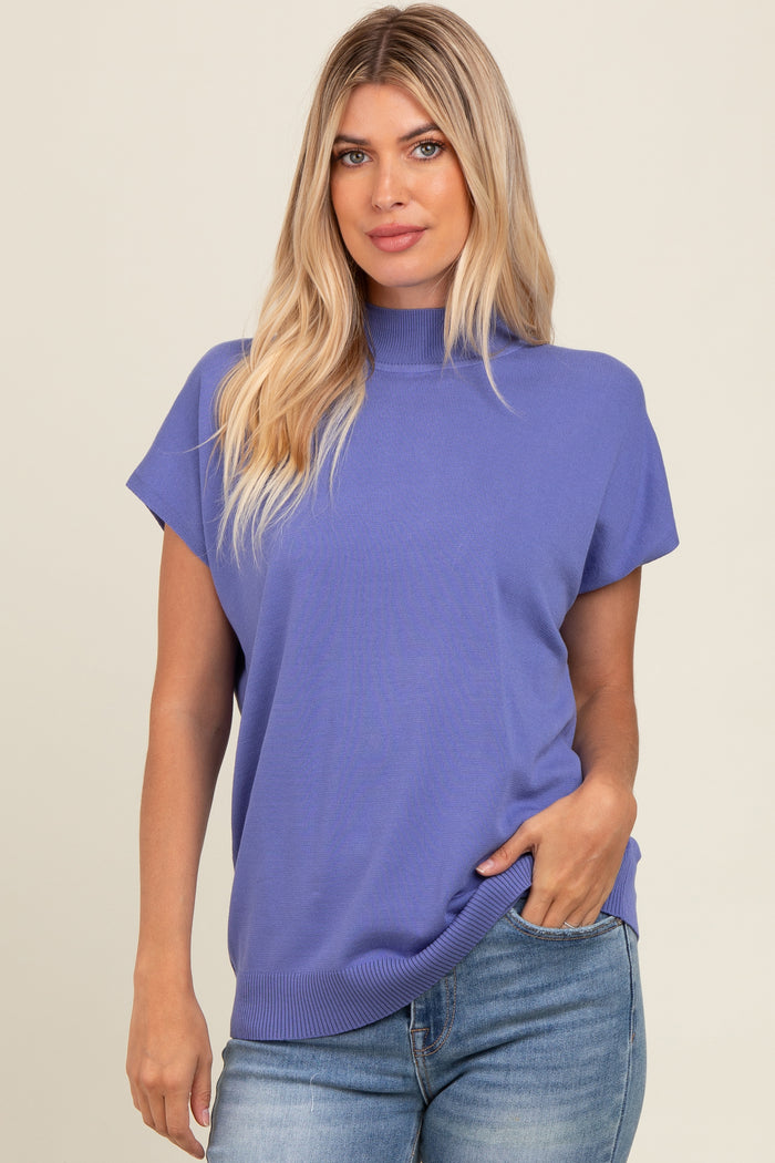 woman wearing a purple short sleeve mock neck sweater and blue jeans