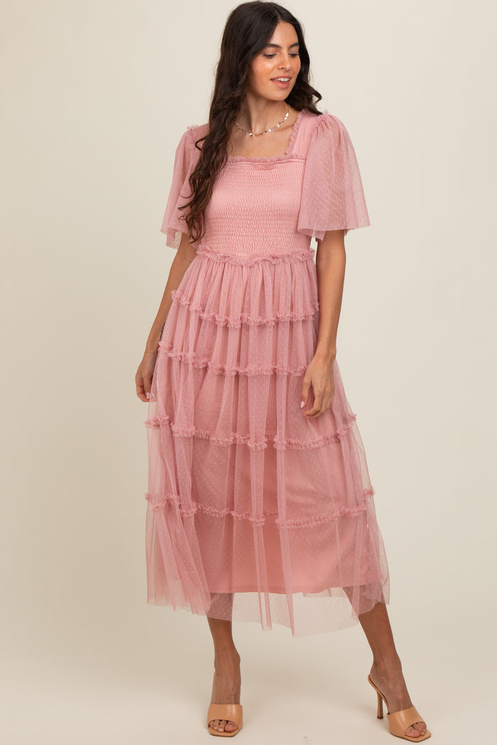 woman wearing a pink tiered midi dress with puff sleeves and a smocked bodice