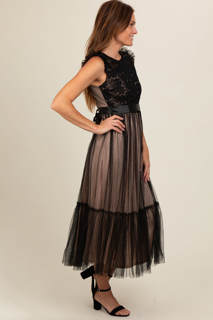woman wearing a black lace and tulle maxi dress with a fitted bodice and tiered skirt, side view