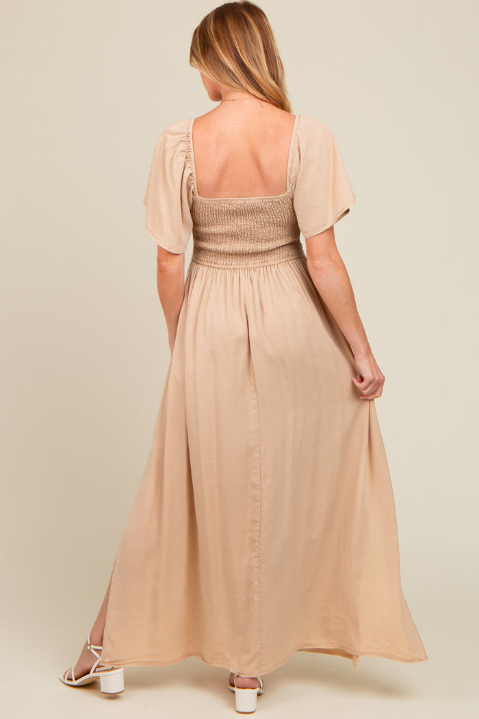 woman wearing a beige maternity maxi dress with short sleeves and a smocked bodice, showing her back