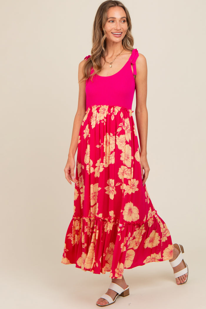 woman wearing a pink ribbed tank dress with floral skirt and ruffled hem, posing and smiling