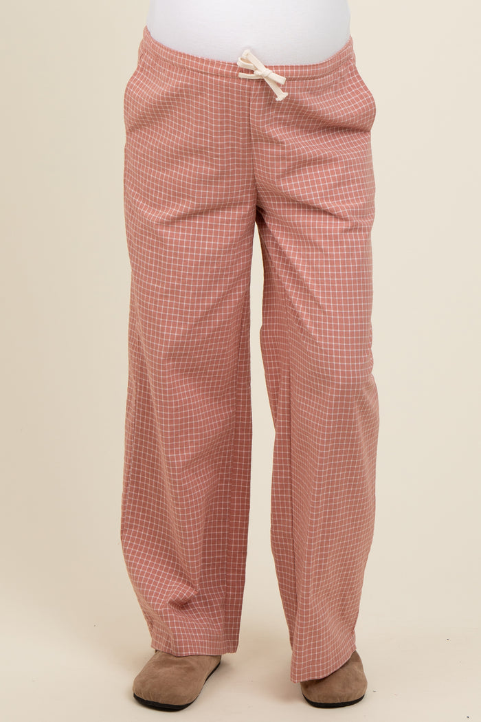 woman wearing light pink checkered maternity pants with a drawstring waist and a visible baby bump