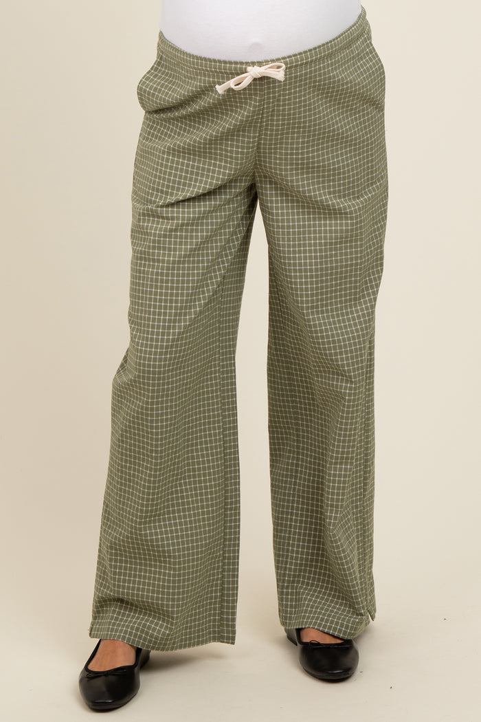 woman wearing green checkered maternity pants with a drawstring waistband and a relaxed fit