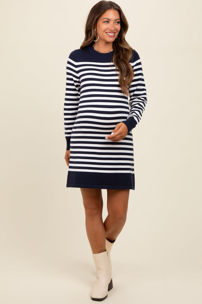 woman wearing a navy and white striped maternity dress with a relaxed fit and long sleeves, showing her baby bump