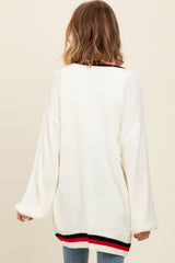 woman wearing an oversized white knitted sweater with a striped hem and long sleeves