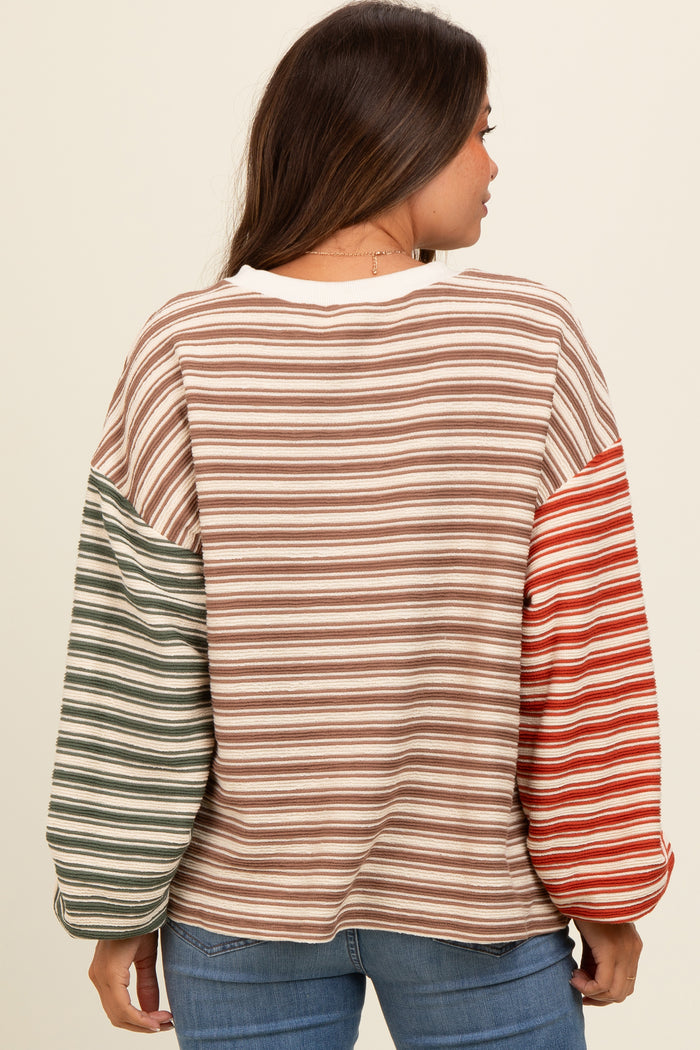 woman wearing a striped maternity top with long, colorful sleeves and a relaxed fit