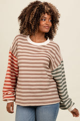 woman wearing a multicolored striped long sleeve top with oversized sleeves and relaxed fit