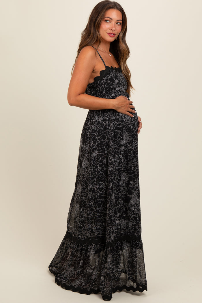 woman wearing a black floral lace maternity maxi dress and holding her baby bump