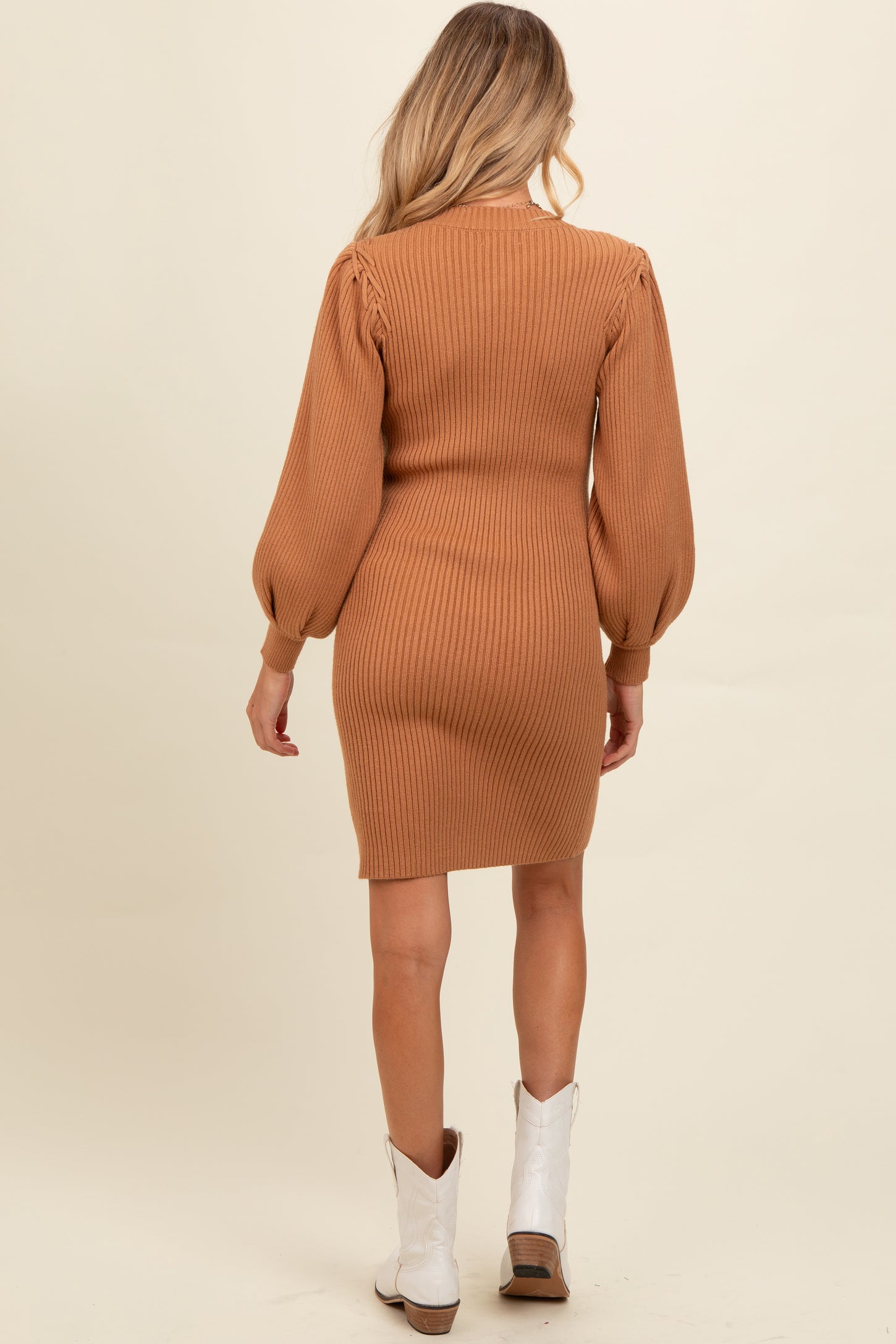 woman wearing a camel ribbed maternity dress with puff sleeves, showing off her baby bump from the back