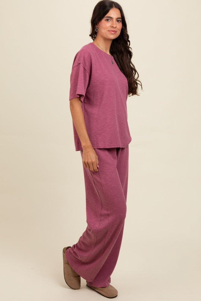 woman wearing a mauve ribbed two-piece loungewear set with short sleeves and wide-leg pants