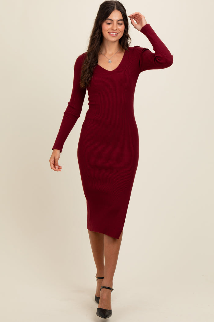 woman wearing a burgundy ribbed midi dress with long sleeves and a v-neckline, walking confidently