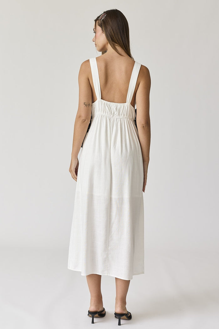woman wearing a white sleeveless midi dress with a gathered back and simple straps