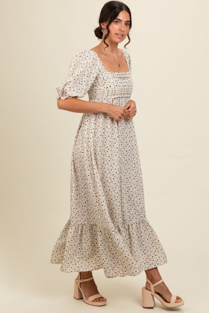 woman wearing a cream floral maxi dress with puff sleeves and a square neckline