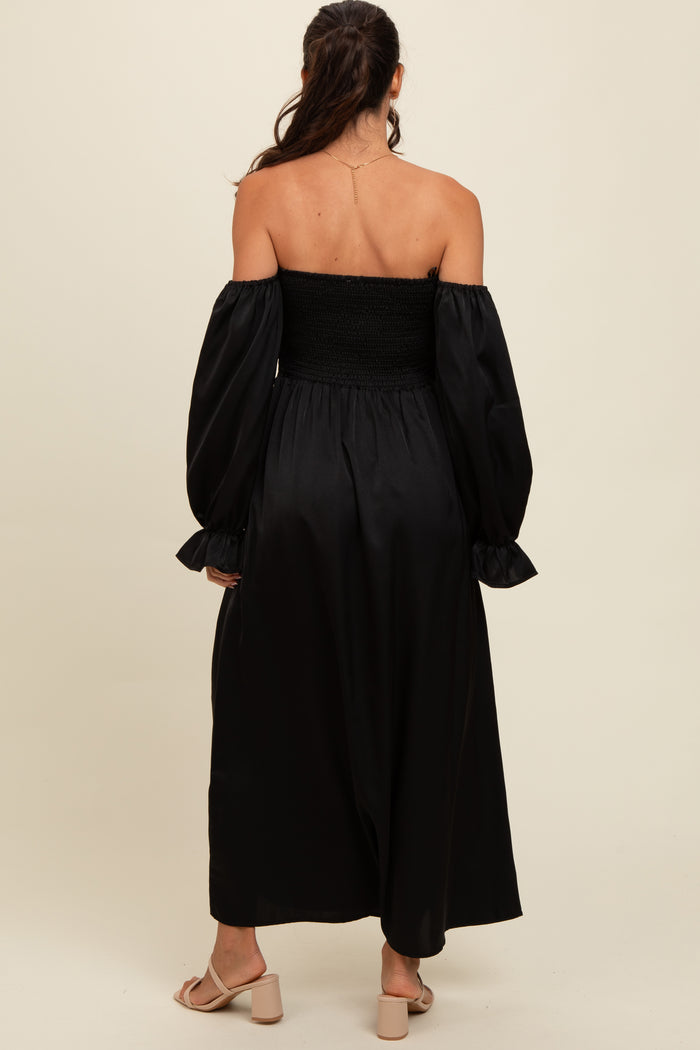 woman wearing a black off-the-shoulder maxi dress with puff sleeves and a smocked bodice, viewed from the back