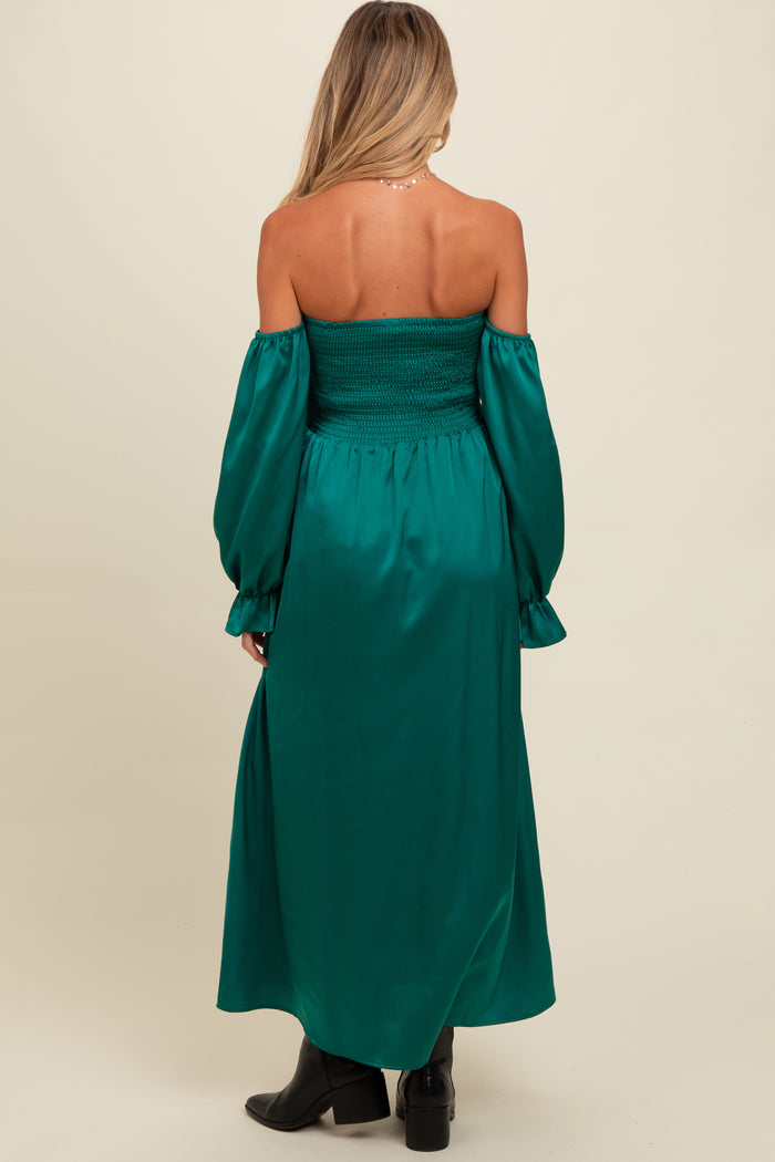 woman wearing a green off-shoulder maternity dress with puff sleeves and smocked bodice seen from the back