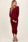 woman wearing a burgundy ribbed maternity dress with long sleeves and a fitted silhouette, showing her baby bump