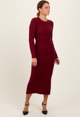 woman wearing a burgundy ribbed long sleeve midi dress with a fitted style and side slit, posing sideways