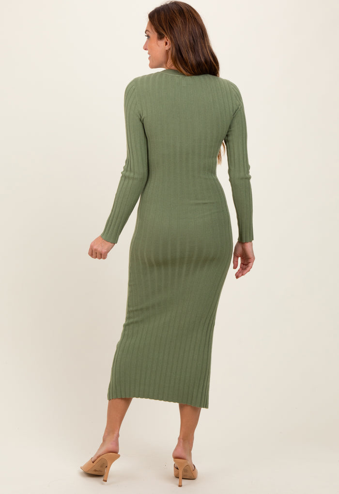 woman wearing a green ribbed long sleeve midi dress, viewed from the back, with a fitted silhouette and a split hem